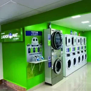 Totem de pagamento e máquinas de lavar e secar em uma unidade Laundromat