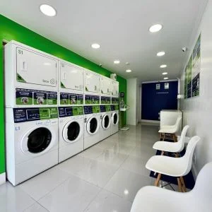 Interior de uma lavanderia Laundromat, com máquinas alinhadas e cadeiras de espera